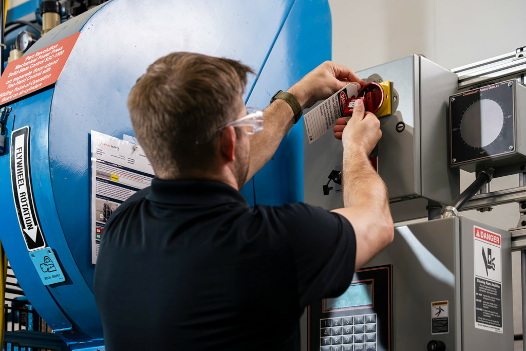 lockout tagout roles - man performing a lockout tagout on a machine
