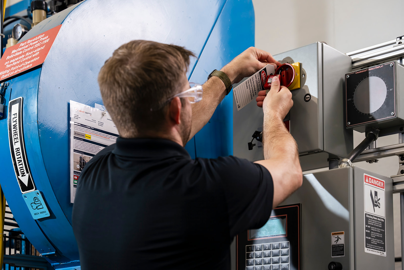 Wentworth LOTO lockout tagout roles - man performing a lockout tagout on a machine